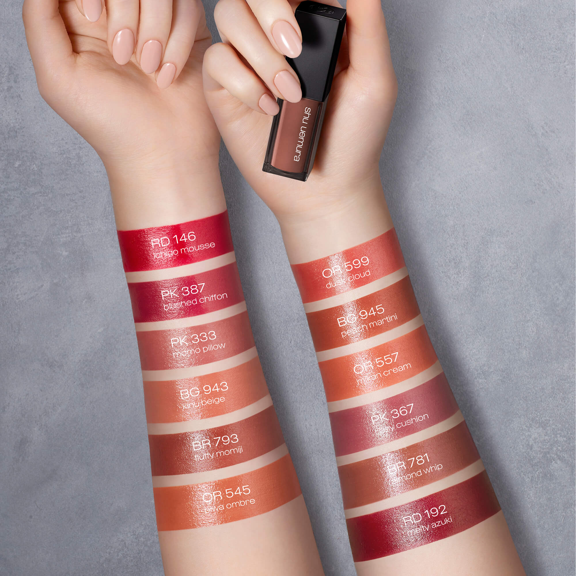 Image 5 - Two forearms display multiple vertical swatches of lip products in shades of red, pink, orange, and brown, with one hand holding a Shu Uemura lipstick tube, featuring text labels RD 146 ichigo mousse, PK 387 blushed chiffon, PK 333 momo pillow, BG 943 kinu beige, BR 793 fluffy momiji, OR 545 okiwa ombre, OR 599 dusk cloud, BG 945 peach martini, OR 557 mikan cream, PK 367 rosy cushion, BR 781 almond whip, and RD 192 melty azuki.